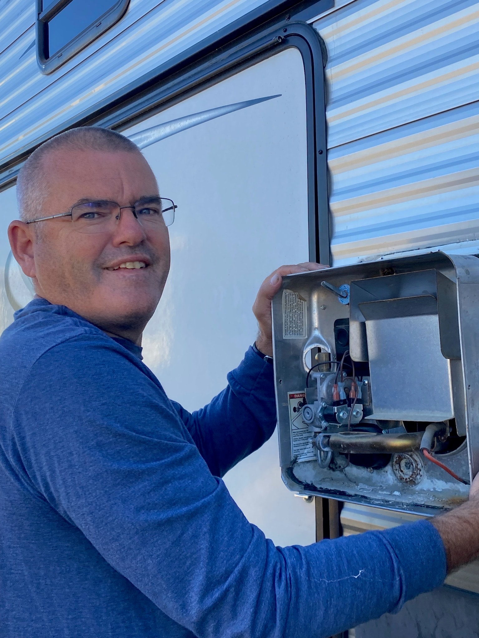 Technician servicing RV water heater outside